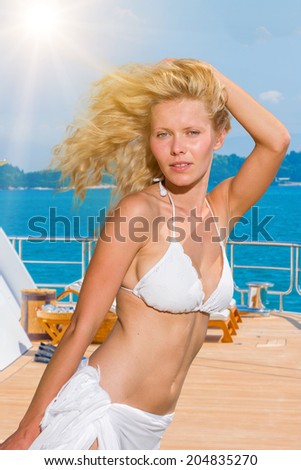 Young woman posing is front of super yacht in Greece