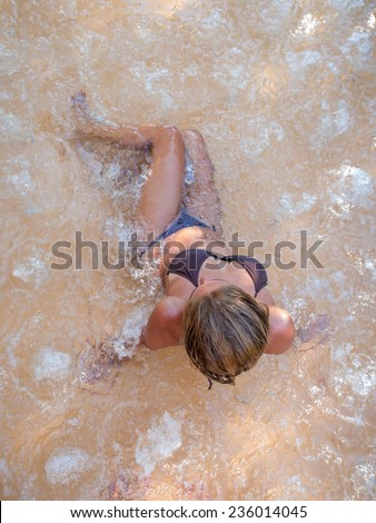 Top view of a  girl in the bubble bath at the swimming pool