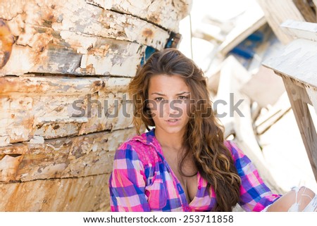 portrait of sexy brunette woman posing in front of shipwreck