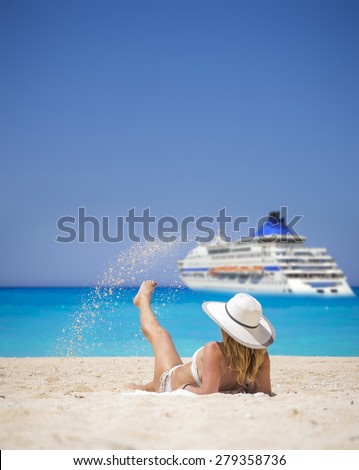 Woman relaxing on the famous Shipwreck Navagio beach in Zakynthos Greece watching a cruiseship passing by