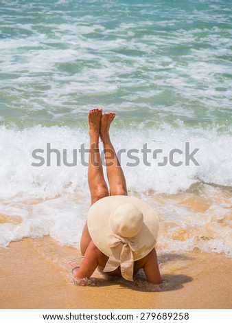 Summer vacation woman on the beach in beach hat enjoying summer holidays looking at the ocean