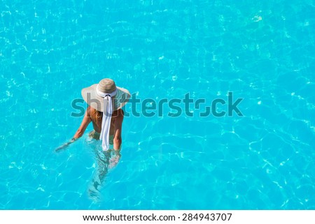 Caucasian model playing into clear water on summer vacation
