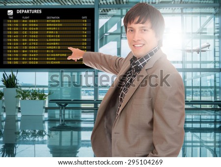 Business man at the airport terminal in front of the departure board
