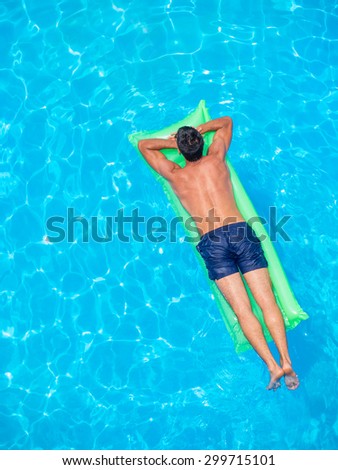 man relaxing on the air bed in the swimming pool.  vacation and free time