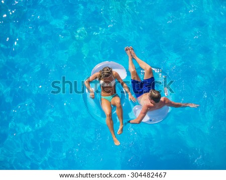 Couple Outside Relaxing In Swimming Pool in the summertime