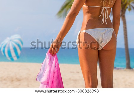 Body part of woman with perfect body on the beach, sexy slim model wearing swimwear and skirt, summer vacation concept