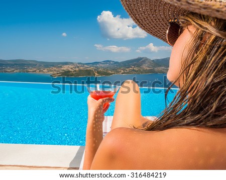 Woman relaxing by the infinity pool in Greece