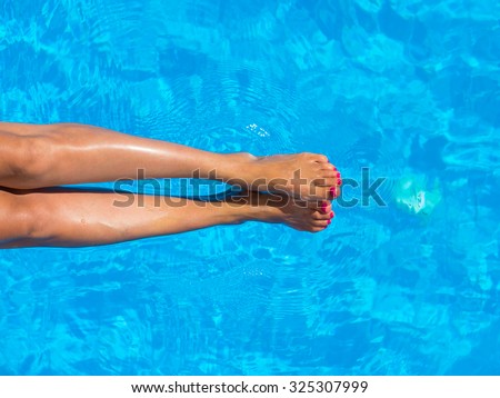 legs of woman lying near the pool . Beautiful female a foot and a heel lifted upwards