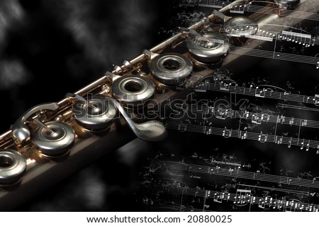 Silver flute instrument resting on a flaming music score