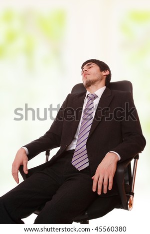Businessman which he fell asleep in armchair.On white background.