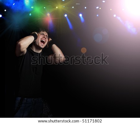 Young Man listening to music with headphones on dark background