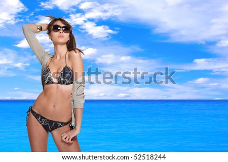 beautiful young bikini model with sea on background