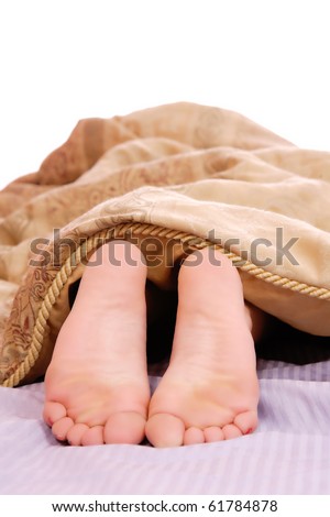 Women\'s feet poking out of the end of the bed