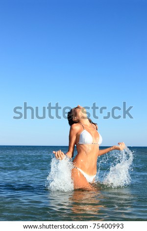 woman splashing in tropical water with white bikini
