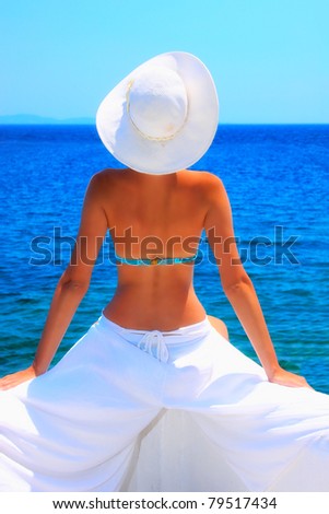 Beautiful young woman relaxing by the beach in Greece