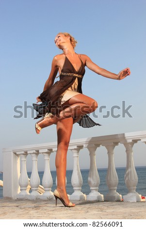 Beautiful young sexy fashion model by the sea at sunset in Greece