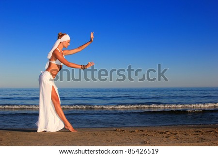 Beautiful young woman relaxing on the beach in Greece at sunset