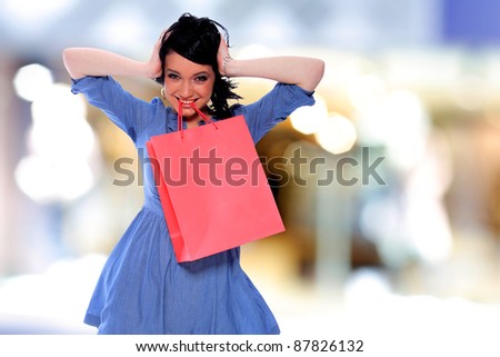 Portrait of an  attractive young girl with shopping bags in front of the shop