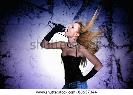 Portrait of a glamorous singer girl holding a mike and singing