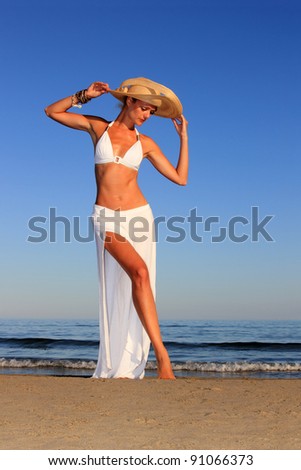 Beautiful woman with hat posing on the beach in Greece