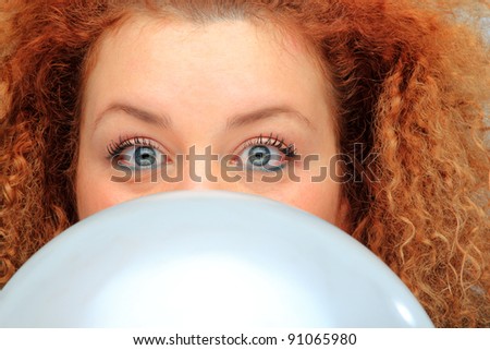 young woman in black shirt inflating balloon