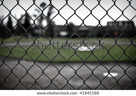 Background of a Baseball Diamond through a chain link fence on a sad day