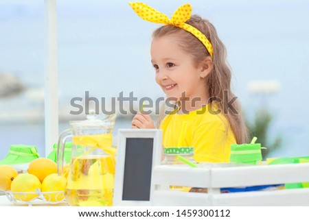 Beautiful girl with a can of lemonade in her hands. Sale of lemonade and lemons. Stok fotoğraf © 