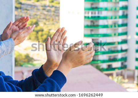 Family applauding medical staff from their balcony. People in Spain clapping on balconies and windows in support of health workers during the Coronavirus pandemic