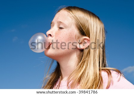 Girl blowing pink bubble gum on white background