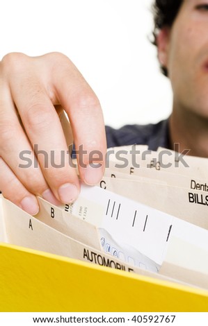 Man filing bills in a alphabet folder