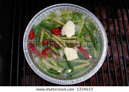 Container of vegetables being cooked on the bbq