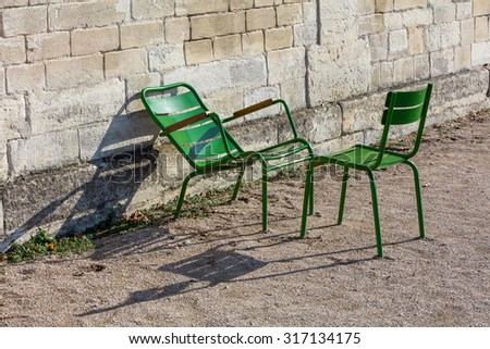 Two green garden chairs in the morning sunlight in the Tuileries Garden, Paris, France.