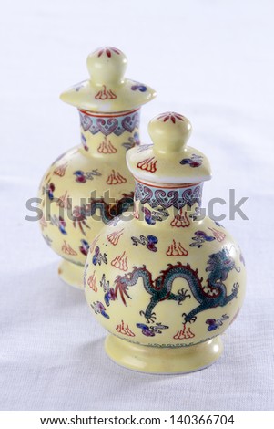 Two porcelain jugs from China, used to store soya sauce or oil, on white background.