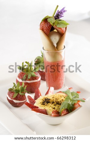 Delicious strawberry sorbet, caramel ice cream, strawberry creme brulee and fresh strawberries in white crockery.
