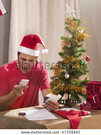 Caucasian man looking at the disastrous Xmas budget and expenses.