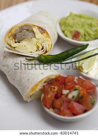 Breakfast burrito, in mexican style,with guacamole, eggs, spice and tomato.