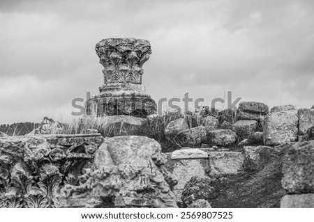 Foto Bild Felsen, der unter Wolkenverhangenem Himmel mickrig klein wirkt.