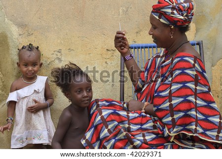 MALI - AUGUST 16: African woman combing her daughters, usual practice in African culture, August 16, 2009 in Mopti, Mali
