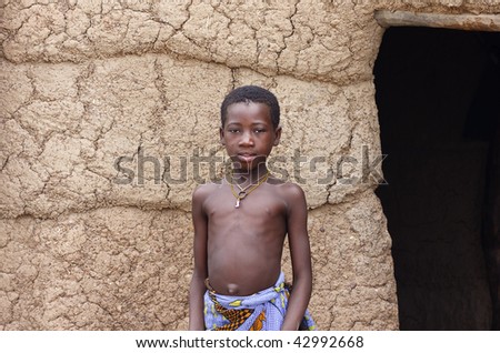 BURKINA FASO - AUGUST 12: Lobi ethnic girl in the doorway of his house, the children take care of their houses while the women cook, August 12, 2009 in Gaoua, Burkina Faso