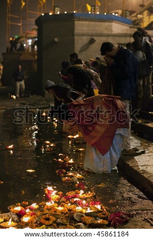 INDIA - DECEMBER 31: Believers make offerings to the river Ganges in the Aarti ceremony with flowers and candles, December 31, 2009 in Varanasi, India
