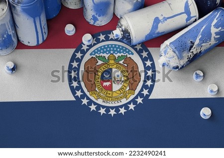 Missouri US state flag and few used aerosol spray cans for graffiti painting. Street art culture concept, vandalism problems Foto stock © 