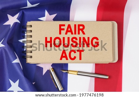 Law and order concept. Against the background of the flag of the United States of America lies a notebook with the inscription - FAIR HOUSING ACT Photo stock © 