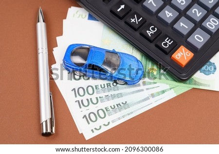 Toy car, calculator and pen on a brown background. Car rental, purchase or insurance. Business concept Foto stock © 