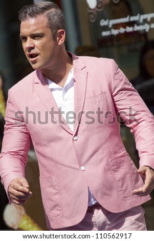LONDON - AUGUST 17: Robbie Williams records the music video for his new song in Londons Spittalfields Market, August 17, 2012 in London, Uk