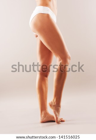 slender legs. tanned skin. studio