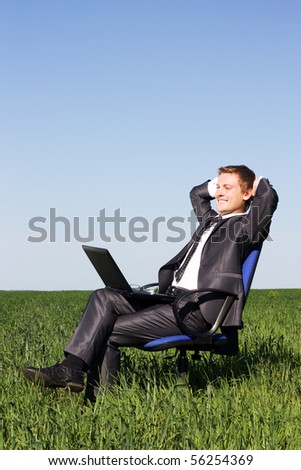 Businessman in the field, with a laptop. Happy, successful