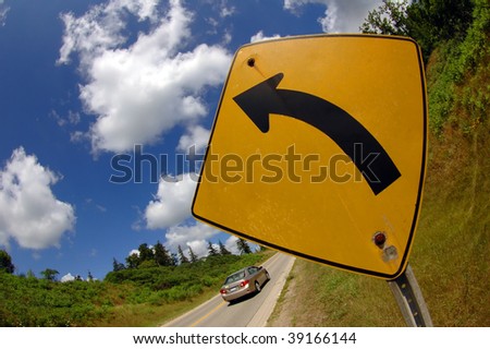 Road signal with a car going in the opposite direction