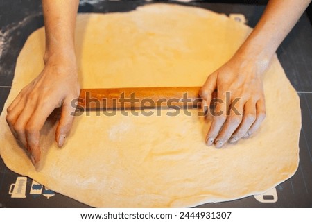 Similar – Image, Stock Photo Anonymous female cook rolling dough while using pasta machine