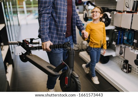 Similar – Image, Stock Photo Electric scooter with shopping bags and woman in background.