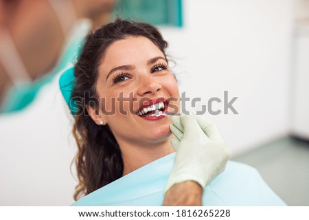 Beautiful woman sitting on dental chair and having dental treatment. Foto d'archivio © 